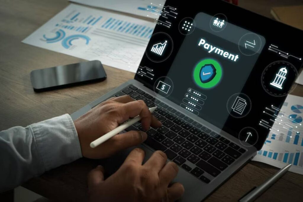 A person using a laptop with a digital payment interface and security features, surrounded by financial data and graphs.