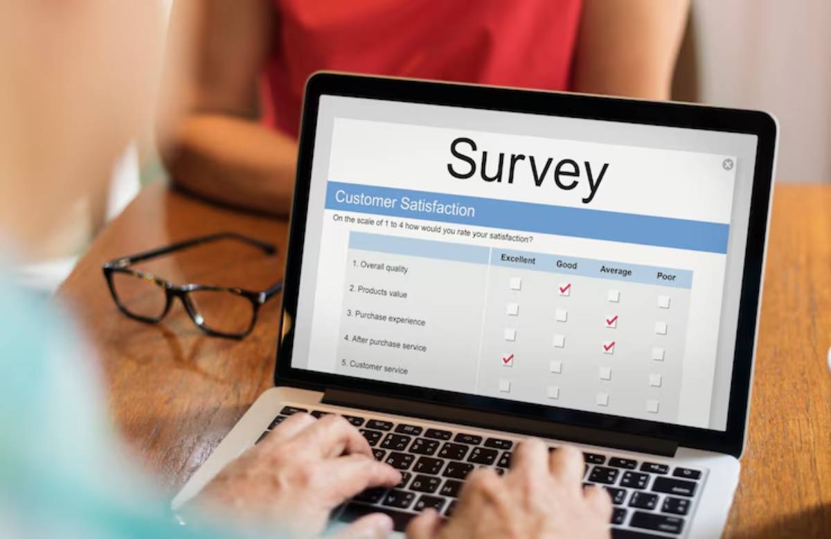 A person fills out a customer satisfaction survey on a laptop, checking responses for various service categories.