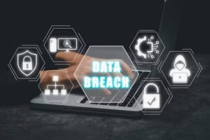 A person typing on a laptop, surrounded by icons representing cybersecurity and data breach threats, with DATA BREACH highlighted.