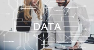 Two professionals, a woman and a man, collaborate on data analysis, highlighted by circuitry graphics overlaying the image.