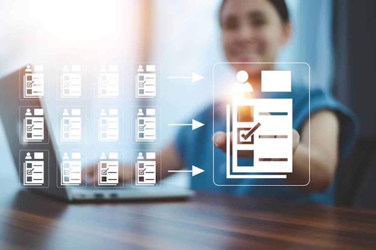 A person reaches out with an icon of a checklist, surrounded by multiple blurred images of similar profiles and a laptop on the table.