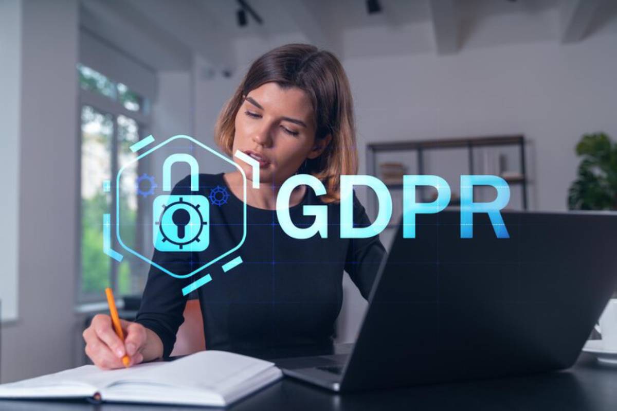 A man in a suit holding a tablet and writing notes, with a digital overlay of the GDPR logo and a padlock symbol to signify data protection.
