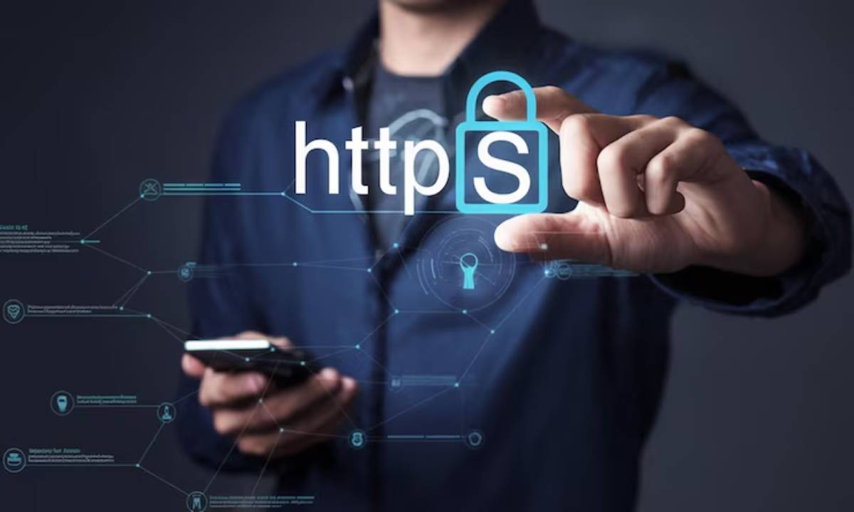 A person in a dark shirt holds a smartphone, highlighting https with a padlock symbol, symbolizing online security.